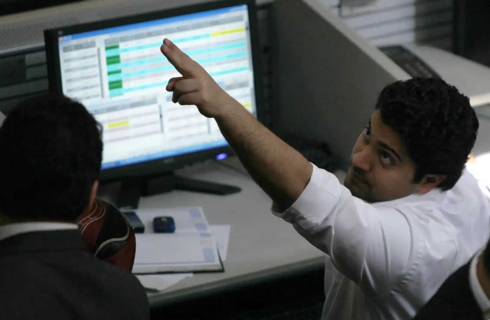 وسيط يتقاعل مع شاشة الأسعار داخل مقر البورصة المصرية 