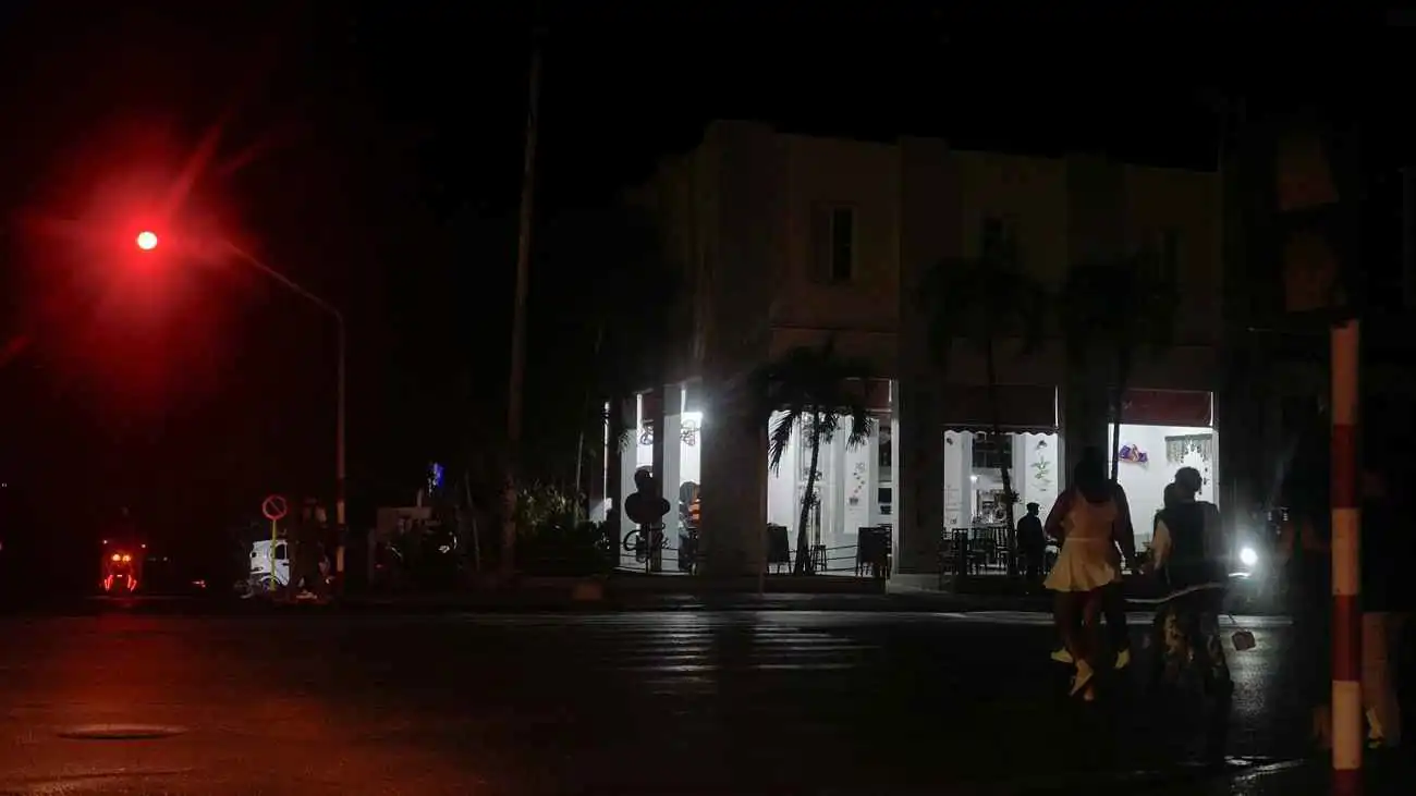 الناس يجتمعون بجوار شركة خاصة مزودة بمولد كهربائي خلال انقطاع التيار الكهربائي على مستوى كوبا في هافانا في 21 مارس 2026.