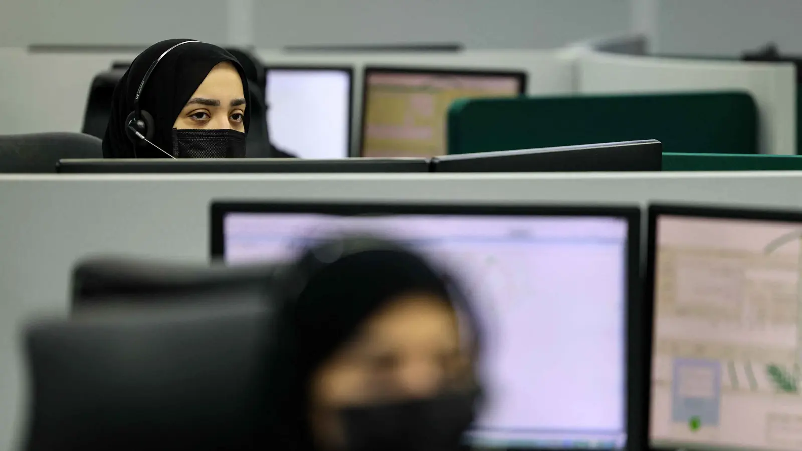 نساء سعوديات يرتدين الكمامات يعملن في مركز القيادة والاتصال بمدينة مكة المكرمة، في 16 يوليو 2021.