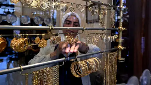 سيدة ترتب مجموعة من الأساور في متجر للذهب بمدينة داريا السورية، 29 أكتوبر 2025.