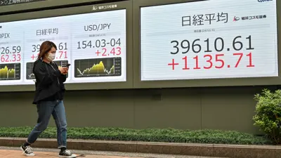 امرأة تمر أمام لوحة إلكترونية تعرض المؤشرات وسعر الين في بورصة طوكيو يوم 6 نوفمبر 2024.