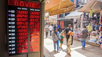 مشاة في أحد أسواق مدينة إسطنبول التركية فيما تظهر أسعار صرف العملات المسجلة في 3 يوليو 2023.