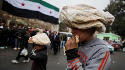 أطفال يأكلون الخبز في أحد شوارع سوريا في 24 ديسمبر 2024