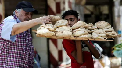 رجل يشتري الخبز من أحد الأسواق الشعبية غرب القاهرة