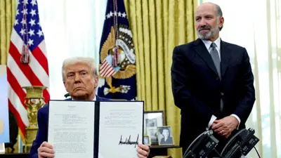 الرئيس الأميركي دونالد ترامب يعرض أمراً تنفيذياً بشأن زيادة الرسوم الجمركية، ويحيط به وزير التجارة هوارد لوتنيك، في البيت الأبيض - 13 فبراير 2025