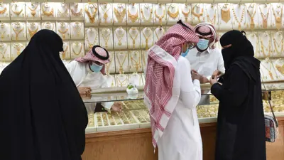 يستعرضون حلياً ومصوغات بأحد محال سوق طيبة للذهب في العاصمة السعودية الرياض يوم 29 يونيو 2020