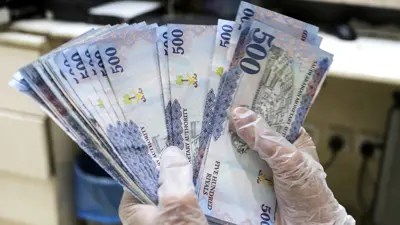 موظف بإحدى شركات الصرافة في السعودية يحمل أوراقاً نقدية من فئة 500 ريال سعودي يوم 10 مارس 2020