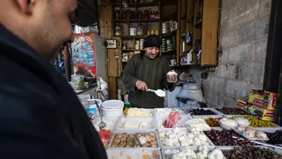 رجل يشتري الجبن من متجر في بلدة دوما شرق العاصمة السورية دمشق في 15 ديسمبر 2024.
