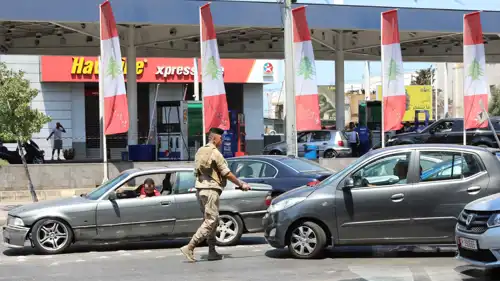 جندي لبناني ينظم حركة المرور أمام محطة وقود في بيروت، 14 أغسطس 2021.