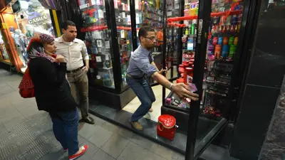 ينظران إلى نافذة عرض لبيع مستحضرات التجميل في متجر بوسط العاصمة المصرية القاهرة يوم 18 أكتوبر 2012