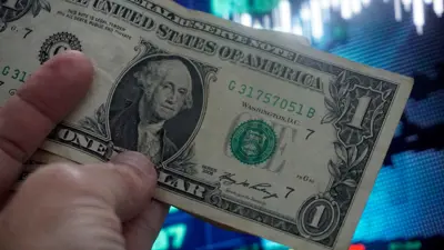يمسك ورقة نقدية فئة واحد دولار في مدينة ساوباولو البرازيلية يوم 27 يونيو 2024