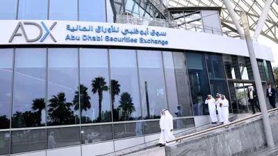 متعاملون خلال خروجهم من مقر سوق أبوظبي للأوراق المالية في العاصمة الإماراتية.