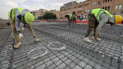 عمال عراقيون يعملون على بناء جسر قيد الإنشاء في شارع أبو نواس في بغداد في 26 نوفمبر 2024.