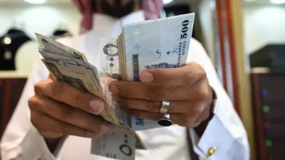 رجل يعد أوراقاً من الريال السعودي داخل سوق طيبة في العاصمة السعودية الرياض يوم 3 أكتوبر 2016.