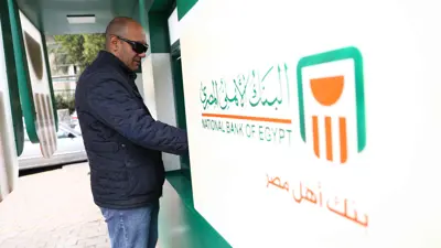 يستخدم ماكينة صرف آلي تابعة للبنك الأهلي في العاصمة المصرية القاهرة يوم 21 مارس 2022.