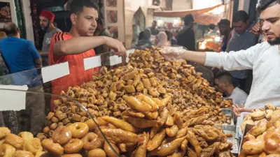 تونسيون يتسوقون في سوق المدينة المنورة بالعاصمة تونس، يوم 15 مايو 2024.
