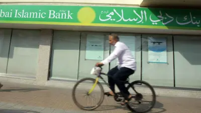 يمرعلى دراجته بجانب فرع بنك دبي الإسلامي في دبي، الإمارات، يوم 3 سبتمبر 2010.