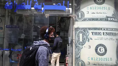 شخص يمر بجوار مكتب صرافة في العاصمة المصرية القاهرة، في يوم 21 مارس 2022.