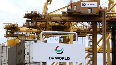 رافعة تحمل شعار شركة تشغيل الموانئ DP World تظهر خلف لافتة الشركة عند مدخل مجمع Port Botany في سيدني في 13 نوفمبر 2023