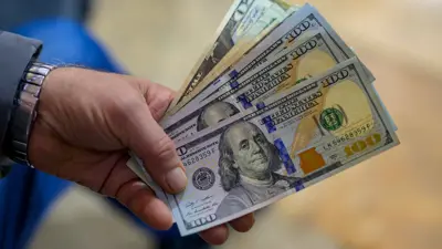 يحمل أوراقاً نقدية من عملة الدولار الأميركي في إسطنبول، تركيا، يوم 28 نوفمبر 2024.