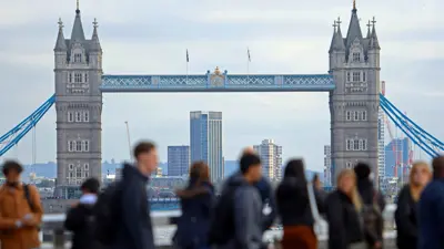 يمشون فوق جسر لندن في حي المال بالعاصمة البريطانية يوم 25 أكتوبر 2023