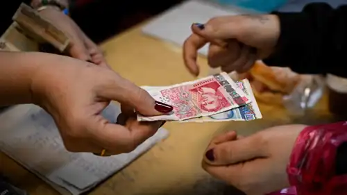 صاحب متجر يعيد أوراق نقدية من فئة الليف إلى أحد العملاء في تشوبرين، شمال غرب بلغاريا، في يوم 7 ديسمبر 2025