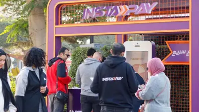 يستعرضون خدمات تطبيق «إنستا باي» داخل جناح في فرع النادي الأهلي بمدينة نصر، القاهرة، مصر، يوم 2 يناير 2023.