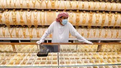 تاجر يقف في متجر مجوهرات بسوق الذهب في مدينة دبي - الإمارات، 12مايو 2020