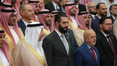 الرئيس السوري أحمد الشرع يتوسط الحاضرين في منتدى الاستثمار السوري السعودي، بحضور وزير الاستثمار السعودي خالد الفالح، 24 يوليو 2025.