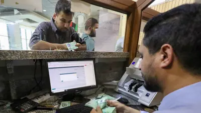 موظف بنك يعدّ أوراقاً نقدية داخل أحد البنوك في مدينة مصراتة، غرب ليبيا، يوم 25 أغسطس 2024.
