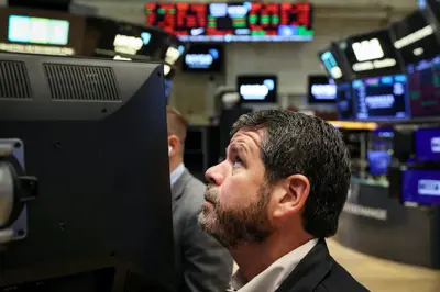 مستثمر يتابع شاشة الأسعار في "وول ستريت"