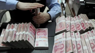 موظف يعد أوراقاً نقدية من فئة 100 يوان في أحد البنوك الصينية