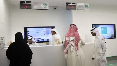 متعاملون داخل فرع تابع لبيت التمويل الكويتي بمدينة الكويت عام 2014.