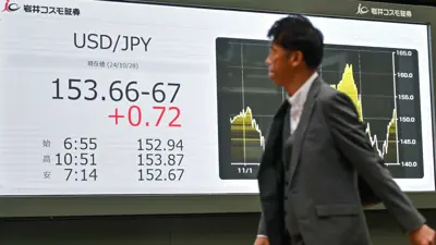 رجل يمشي أمام لوحة إلكترونية تعرض سعر تداول العملات الأجنبية، طوكيو في 28 أكتوبر 2024. 