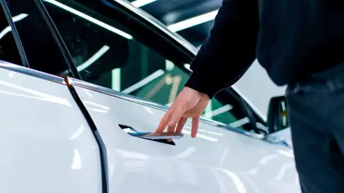 سائق يفتح باب سيارته الكهربائية من نوع «تسلا» عبر مقبض قابل للسحب