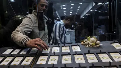 بائع ذهب يقوم بفرز سبائك وعملات ذهبية داخل متجر في «سوق الذهب»، القاهرة، مصر، 12 يناير 2024.