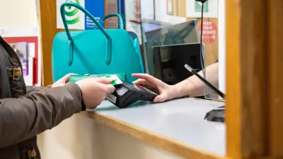 شخص يستخدم بطاقة بنكية للدفع في عيادة طبية، أبريل 2024.