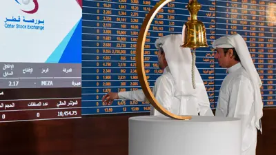 مستثمران يتابعان شاشة التداول في بورصة قطر بالعاصمة الدوحة، يوم 23 أغسطس 2023