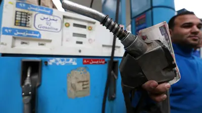 موظف داخل محطة بنزين في القاهرة يستعد لتزويد مركبة بالوقود.