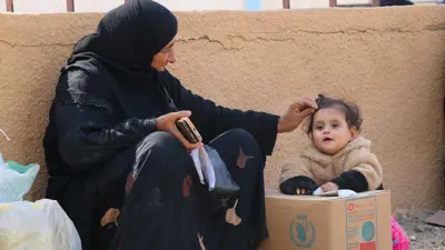 طفلة فلسطينية تضع يديها على مساعدات غذائية مقدمة من برنامج الأغذية العالمي، 25 أغسطس 2025.