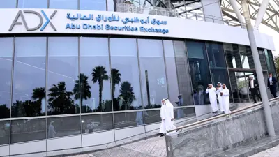 متعاملون خلال خروجهم من مقر سوق أبوظبي للأوراق المالية في العاصمة الإماراتية.