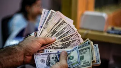يحمل أوراقاً نقدية من الدولار الأميركي في إحدى أسواق مدينة القامشلي السورية يوم 10 سبتمبر 2019.
