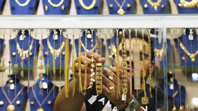 يرتب معروضات من المصوغات الذهبية على واجهة أحد محال مدينة الكويت يوم 31 أكتوبر 2024.