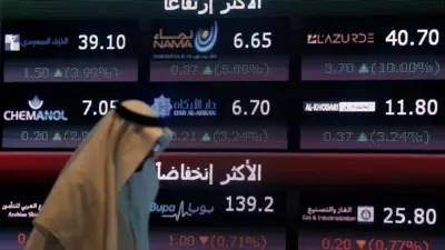 رجل يمر أمام شاشة التداول في السوق المالية السعودية بالعاصمة الرياض يوم 29 يونيو 2016.