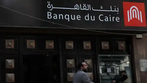 رجل يسير أمام فرع لبنك القاهرة في العاصمة المصرية القاهرة، 18 مارس  2020.