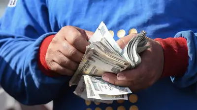 عامل يعد النقود في محطة وقود في القاهرة، مصر، يوم 26 يوليو 2024