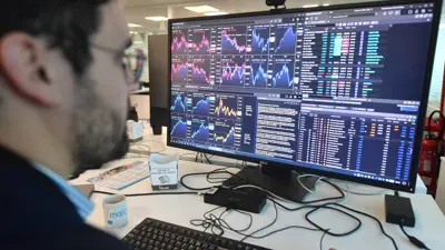 متعامل يتابع شاشات التداولات في بورصة نيويورك.