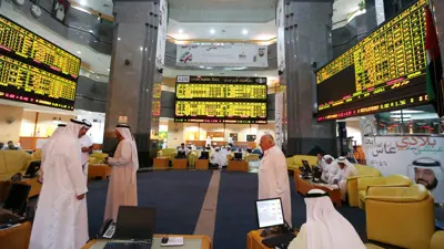 مستثمرون يراقبون الشاشات التي تعرض معلومات الأسهم في سوق أبوظبي للأوراق المالية يوم 25 يونيو 2014