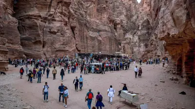 سياح يتجولون في أطلال مدينة البتراء القديمة في جنوب الأردن في 12 ديسمبر 2022