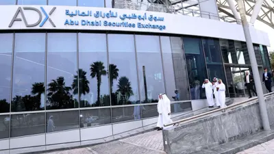 متعاملون خلال خروجهم من مقر سوق أبوظبي للأوراق المالية في الإمارات.